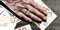 Hand of elderly woman on table with euro